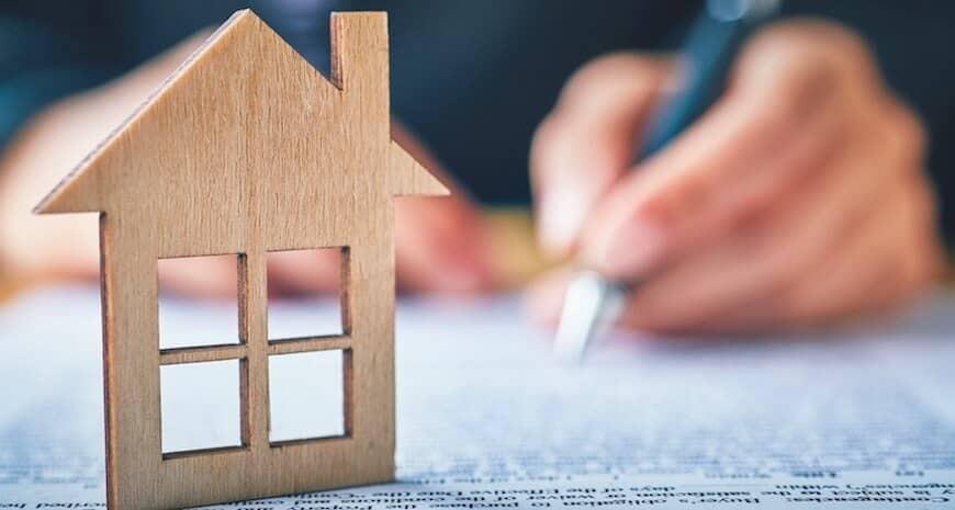 house figure on top of documents being signed